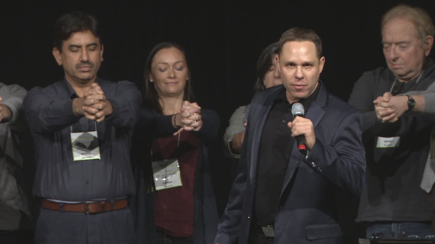 Randy Charach, magician for hire, with group of people on stage.