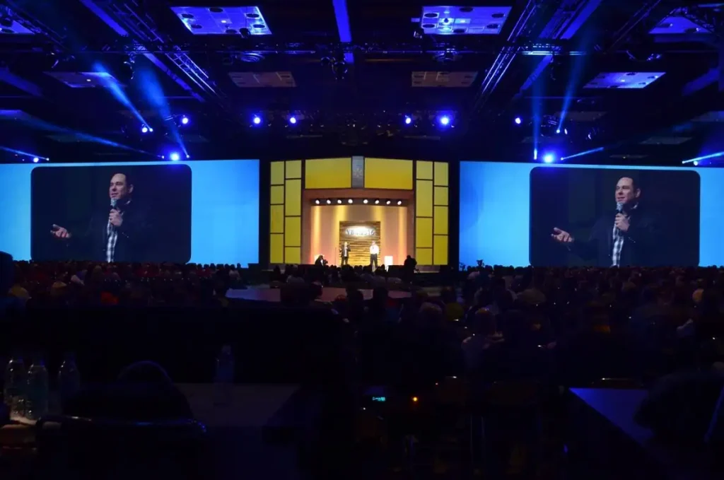 Randy Charach, been shown on big screen on a stage on one of his show